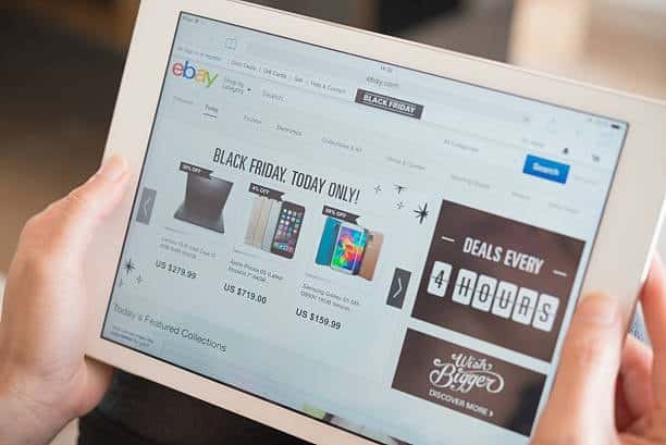 Person viewing eBay product listings on a tablet, illustrating how seller handling time impacts shipping expectations.