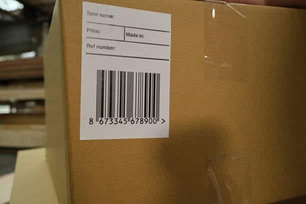 Brown shipping box with a printed barcode label representing Amazon FBA labeling requirements