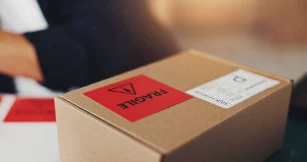 Brown carton with fragile warning label and shipping label similar to Amazon FBA box label format