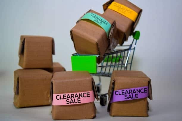 Brown cardboard packages labeled clearance sale in a shopping cart representing imported goods ready for custom duty clearance