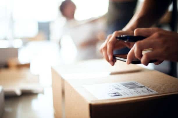 scanning dropshipping package label with smartphone for delivery tracking