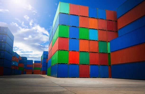 Colorful rows of stacked shipping containers under a bright sky.
