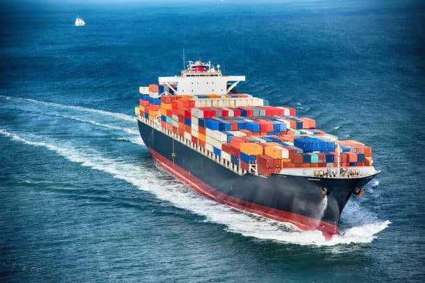 Container ship loaded with cargo moving at high speed, illustrating ocean freight transit efficiency.