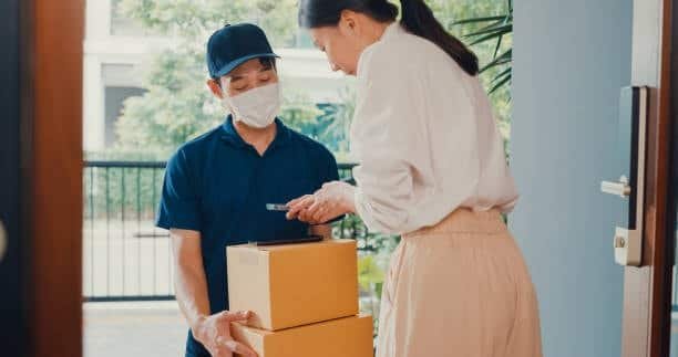 Door-to-door courier handing a large box directly to the customer.