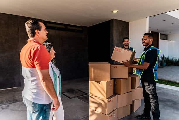 Courier receiving mobile payment from customer at the doorstep during delivery.