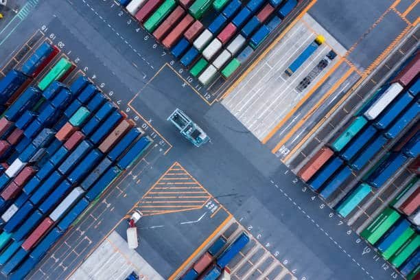 Top-down view of colorful shipping containers in a logistics terminal used in ground shipping operations.
