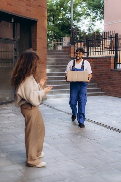 Door-to-door moving team unloading boxes and assisting customers at home.