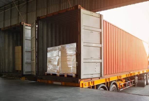 “Full container load (FCL) with palletized goods being loaded in red shipping container truck”