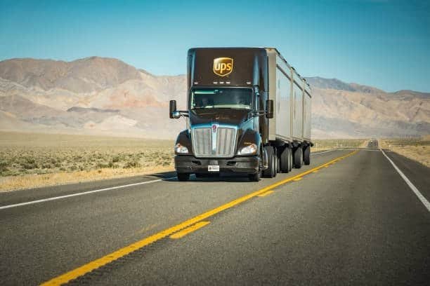 Discount on shipping using UPS truck delivering goods across highways.