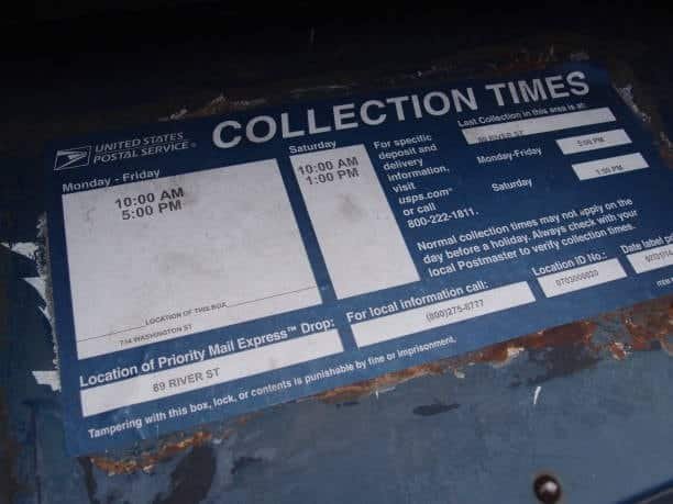USPS mailbox with collection times schedule displayed.