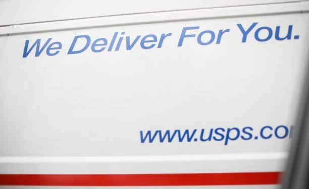 USPS van showing delivery slogan and website link.