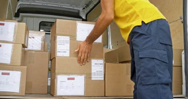 “Worker loading cartons in van representing cargo handling and documentation in CFS costs”