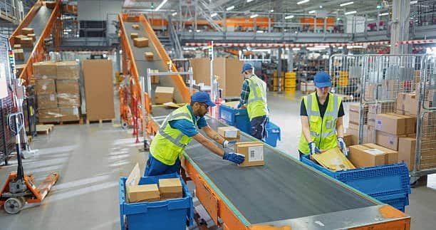 E-commerce fulfillment center employees sorting and preparing packages for shipping.