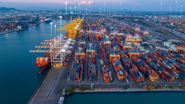 Aerial view of a modern smart port with digital connectivity overlay above shipping containers.