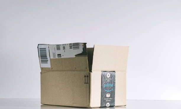 Stack of Amazon Prime boxes at home entrance showing various compliant packaging sizes