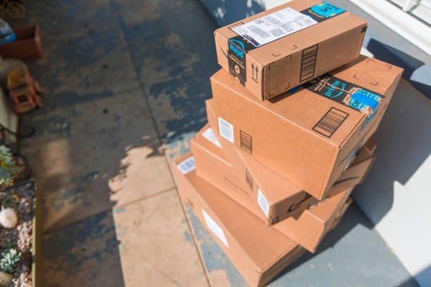Multiple Amazon boxes stacked at doorstep showing proper outer packaging and labelling