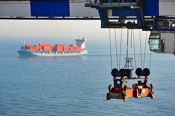 Cargo ship at sea with crane hook symbolizing risk transfer in FOB terms.