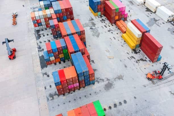 Aerial view of stacked shipping containers in a container freight station storage area.