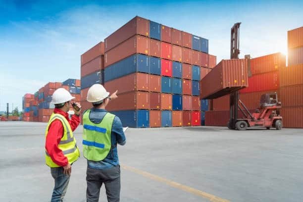 Workers monitoring container stacking and movement at a CFS container yard.