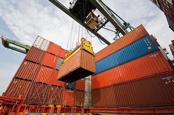 Large crane lifting a freight container during CFS loading and unloading operations.