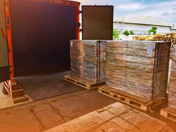 Palletized cargo being unloaded from a truck after being cleared from customs