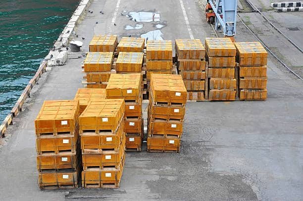 Stacked yellow crates at port ready for loading after receiving customs clearance
