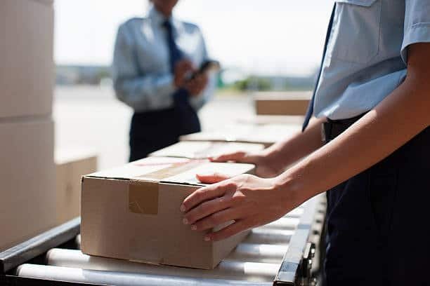Customs officers inspecting and handling a parcel during the customs clearance process