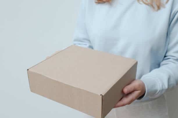 Customer receiving a delivery box from door to door courier.