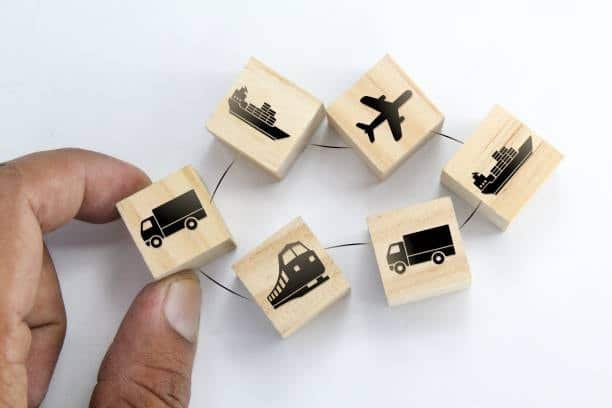 Cubes with icons of truck, ship, airplane, and train illustrating multimodal transport allowed under FCA Free Carrier terms.