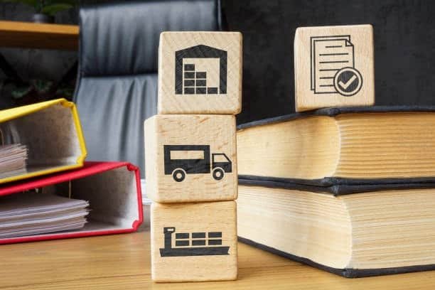 Wooden blocks showing warehouse, truck, ship, and document icons representing responsibilities in FCA Free Carrier terms.