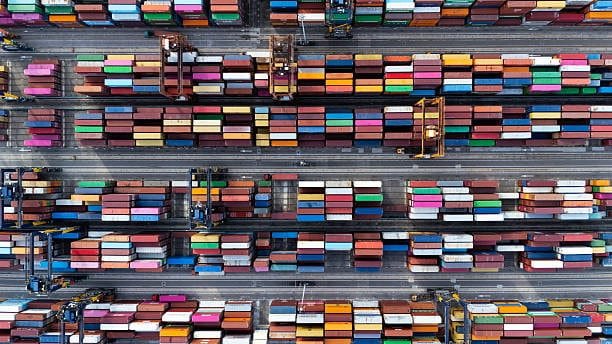 Aerial image of hundreds of shipping containers arranged in rows for ground transport.