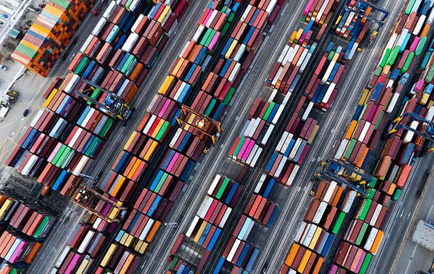 Top-down view of colorful shipping containers organized for transportation and ground shipping.