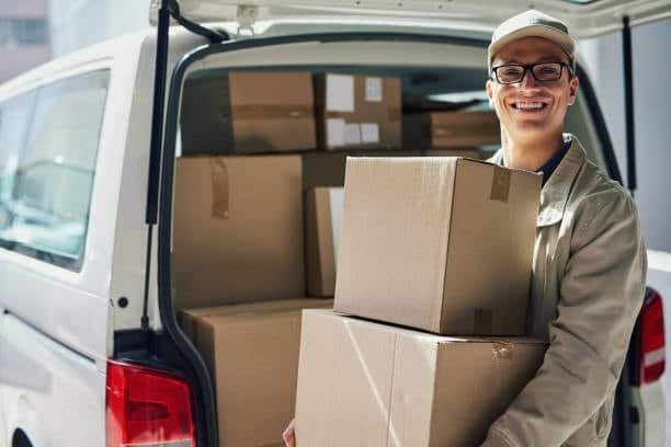 Door to door courier unloading packages from delivery van.