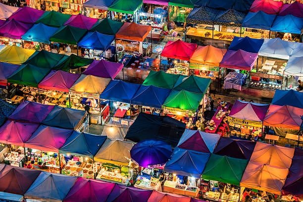 Colorful marketplace stalls symbolizing small business imports requiring customs duty processing.