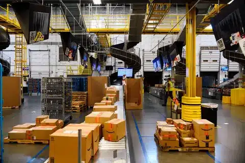 Packages on sorting belts inside modern fulfillment center logistics facility.