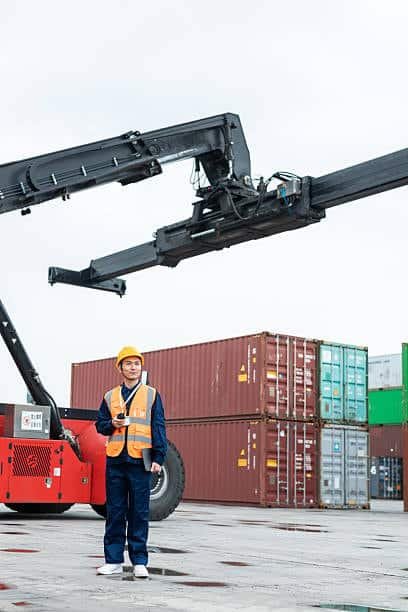 Port worker monitoring shipping containers under Freight on Board terms.