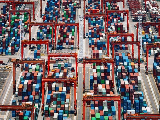 Aerial view of automated port cranes moving containers along international shipping routes.