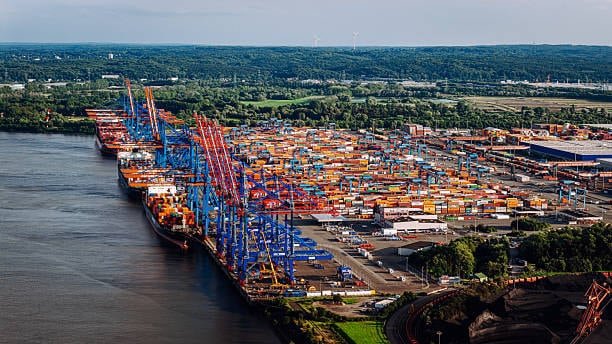 Large seaport terminal with cranes operating in international shipping channels.