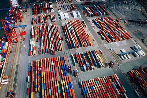 Top-down view of a busy container yard used in global shipping channel operations.