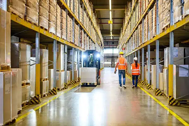 Logistics workers inside warehouse organizing goods and pallets