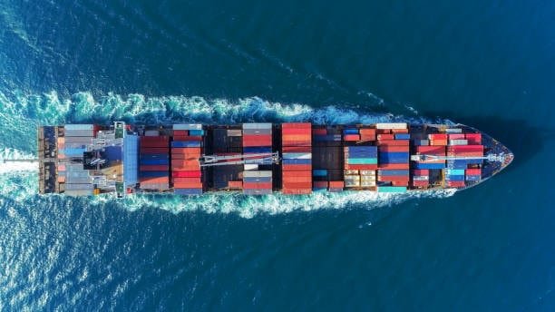 Aerial view of cargo ship transporting containers across international waters.