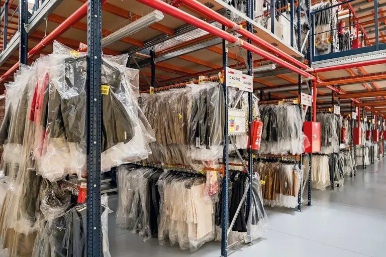 Clothes hanging in a warehouse ready for picking and packing in an apparel fulfillment center.