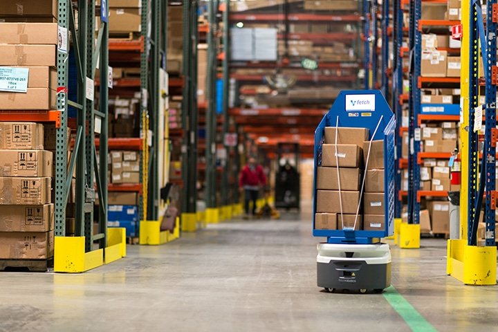 Autonomous warehouse robot transporting apparel boxes for efficient DTC order fulfillment.
