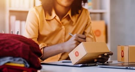 Seller preparing and labeling package for AliExpress delivery.