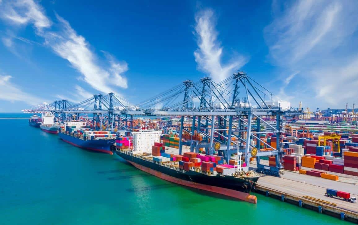 Cargo ships and containers at a major Southeast Asian port representing regional manufacturing growth and supply chain shifts after APEC 2025.