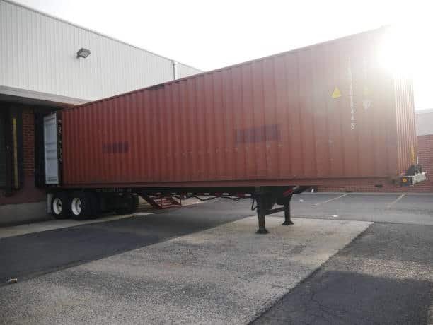 SOC container being loaded on a truck at the warehouse shipping dock.