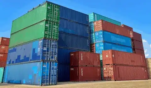 SOC and COC shipping containers stacked at a container yard ready for global transportation.