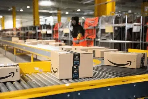 Close-up of Amazon boxes on a conveyor belt in a fulfillment center.