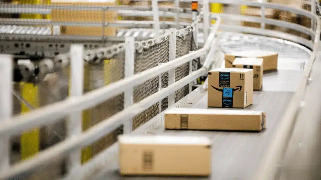 Amazon FBA boxes traveling on a conveyor system inside a fulfillment center.