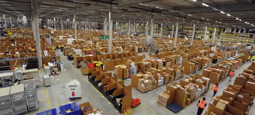 Wide view of an Amazon FBA warehouse showing large storage areas and workers managing inventory.